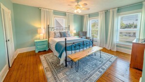 A bedroom with a bed, bedside tables, a bench, and a ceiling fan. - Fun in the Sun Home with Game Shed, Near Beach (Cape Charles)