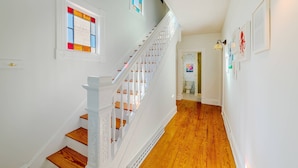 A staircase with white railings and wooden steps leading to a room with a window and a door. - Fun in the Sun Home with Game Shed, Near Beach (Cape Charles)