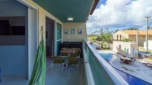 A balcony with a pool, outdoor seating, and a hammock. - Villas do Atlântico próximo ao mar (Ipojuca)