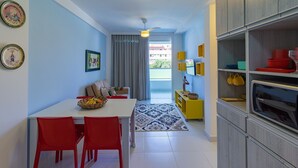 A modern kitchen with a dining area, a ceiling fan, and a view to the outside. - Villas do Atlântico próximo ao mar (Ipojuca)
