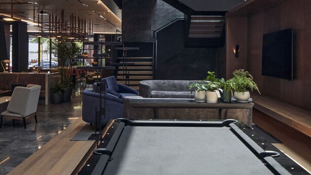 A spacious lobby with a central seating area, a staircase, and a large window allowing natural light. - Pullman Lima Miraflores (Lima)