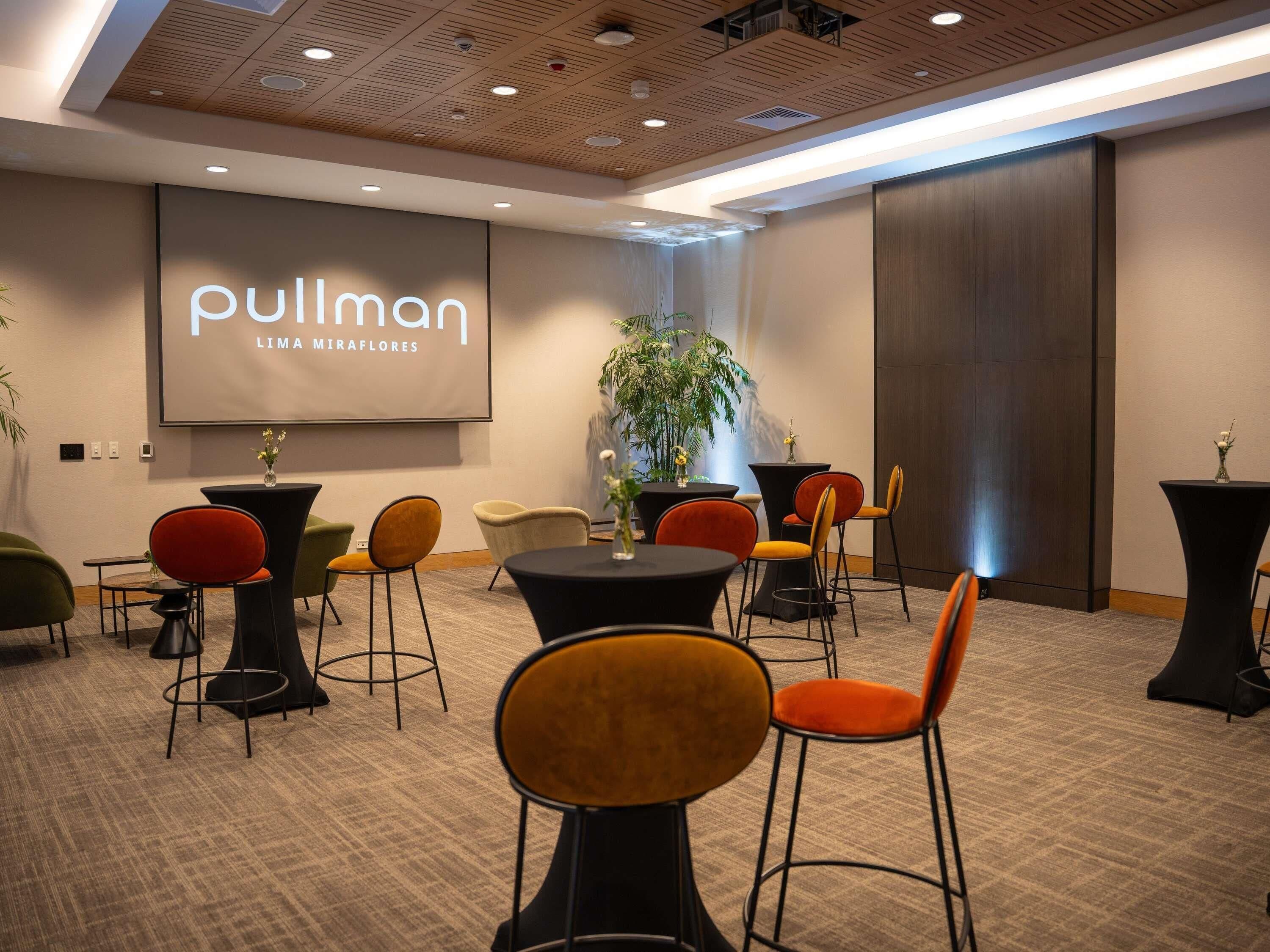 Une salle de conférence dotée d’un grand écran affichant les mots « Pullman » et « LIMA MIRAFLORES ».