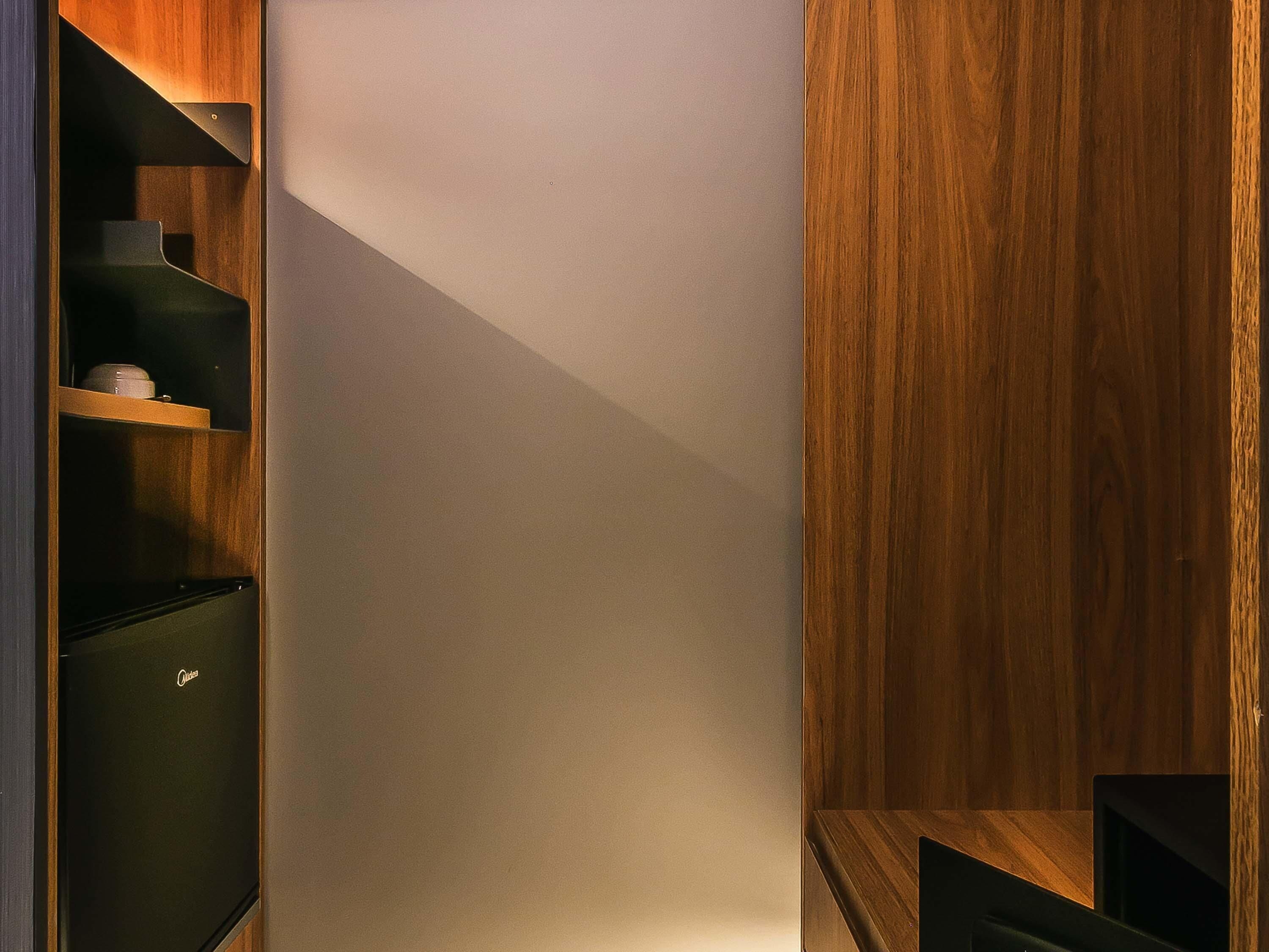 A modern, minimalist interior with a wooden accent wall and built-in shelving.