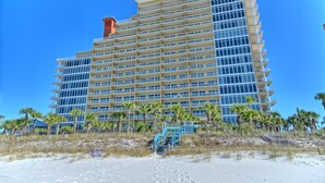 A multi-story hotel with a modern design, featuring numerous balconies and a prominent red chimney.