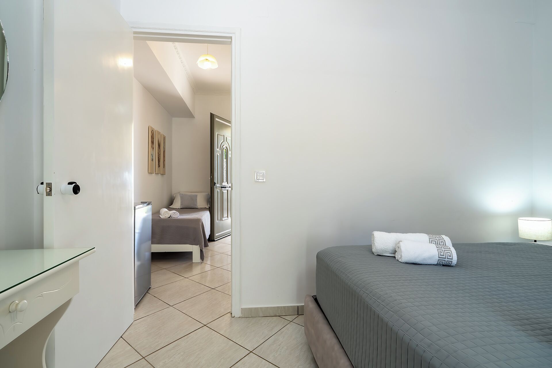 A hotel room with a bed, a bathroom, and a door leading to another room.
