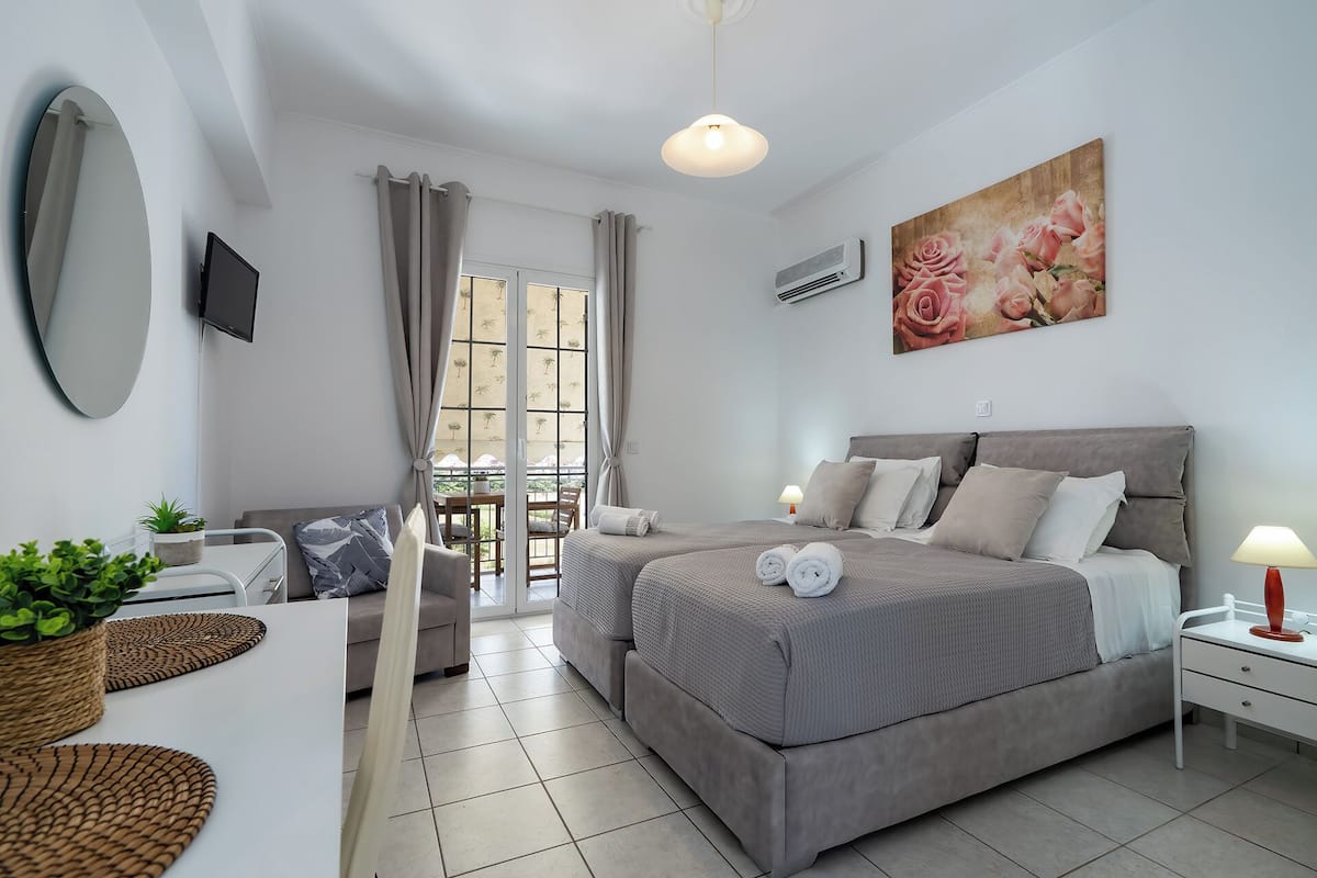 A modern bedroom with a large bed, bedside tables, a TV, and a painting.