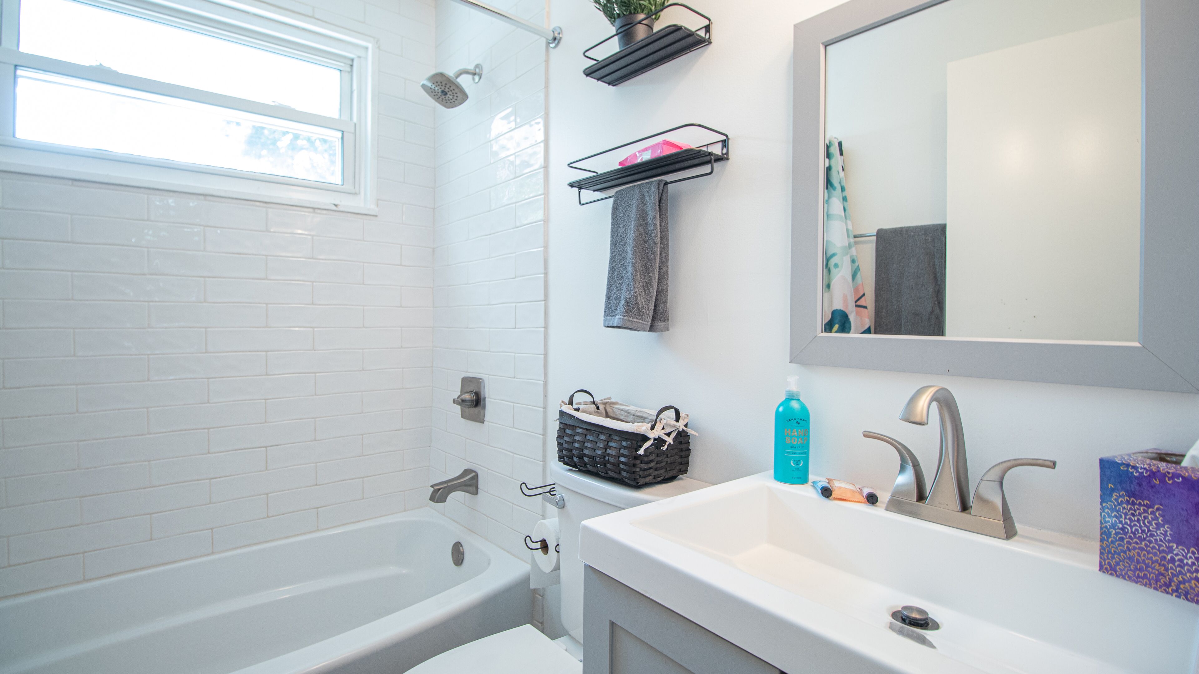 A modern bathroom with a bathtub, a sink, a mirror, and a shower.