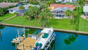 A marina with a docked boat, a swimming pool, and a house with a red roof. - Waterfront  (Clearwater)