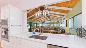 A modern kitchen with white cabinetry, a stainless steel sink, and a built-in dishwasher. - Large Home in Waikoloa Village | 5-Bedrooms | Newly Updated with AC (Waikoloa)
