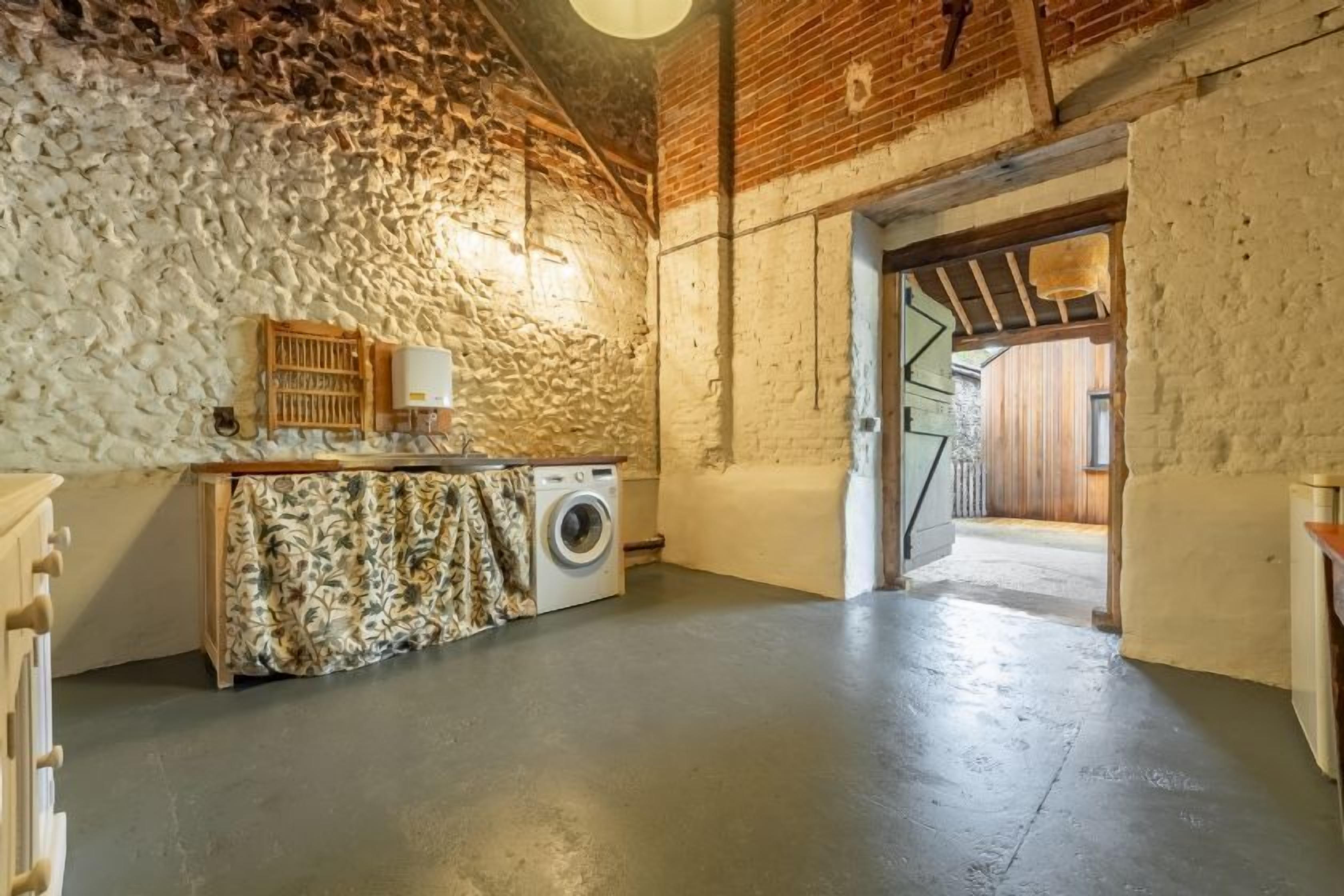 Una sala de lavandería con lavadora, un tendedero y un armario de madera.