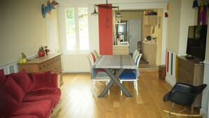 Een eethoek met een tafel, stoelen en een rode bank.