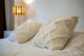A bed with two white pillows and a lamp in the background. - Mogro Cove   (Mogro)