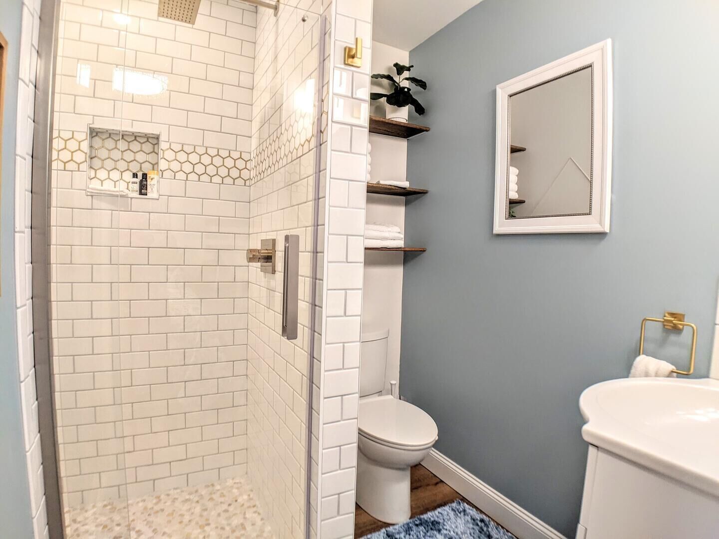 Une salle de bain avec douche, toilettes et lavabo.