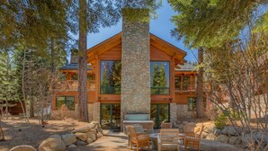 A modern log cabin with a stone facade, large windows, and a patio with outdoor furniture. - Mountain Bear Lodge At Northstar - TLUXP (Truckee)