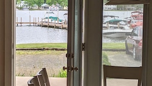 An open door leading to a view of a marina with boats and a dock. - Winnisquam Lakeside Retreat w/Sandy Beach & Boat Docks (Tilton)