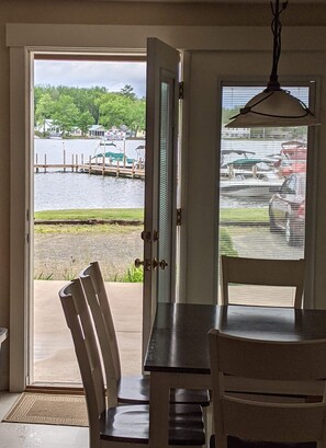 An open door leading to a view of a marina with boats and a dock.