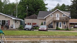 A house with a garage, a covered porch, and a small deck. - Winnisquam Lakeside Retreat w/Sandy Beach & Boat Docks (Tilton)