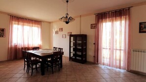 A dining room with a wooden table and chairs, a chandelier, and a bookcase. - Villa Green a Venticano: Soggiorno sereno nel cuore del Taurasi (Venticano)