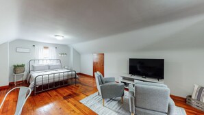 Una habitación moderna y bien iluminada con cama, televisión y zona de estar.