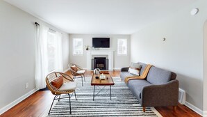 Un salón amplio con chimenea, televisor de pantalla plana y asientos cómodos.
