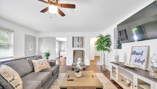 Un salon moderne comprenant un canapé, une table basse, un téléviseur et des objets de décoration.