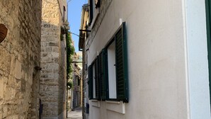 Un estrecho callejón con paredes de piedra y un camino empedrado.