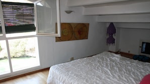 A bedroom with a large bed, a window with blinds, and a wall-mounted artwork. - charming house (Villacarlos)