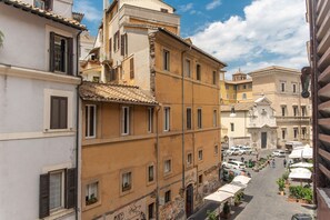 Une rue étroite bordée d’immeubles à plusieurs étages, dont certains sont dotés de balcons et de fenêtres.