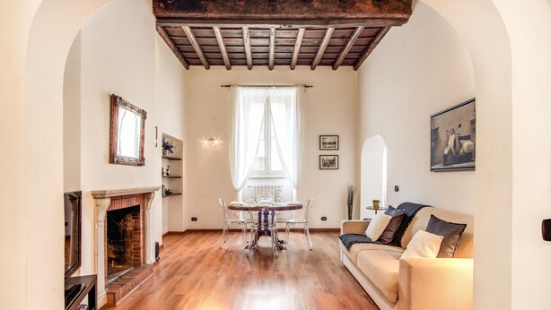 Ein geräumiges Wohnzimmer mit Kamin, einem Esstisch und einer Couch.