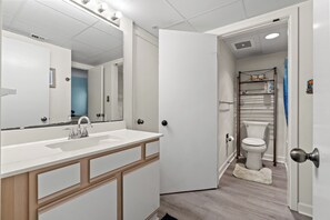 Ein Badezimmer mit Waschbecken, Spiegel und Toilette.
