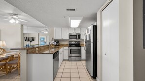 A modern kitchen with white cabinets, stainless steel appliances, and a central island.