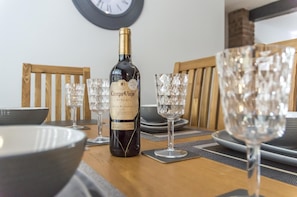 Enjoy a formal dining experience with a beautifully set table, complete with fine wine and elegant glassware.