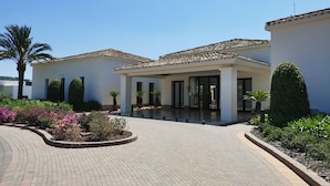 A modern building with a tiled roof, a covered entrance, and a paved driveway.