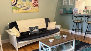 Ein Wohnzimmer mit einer Couch, einem Couchtisch und einem gemusterten Teppich.