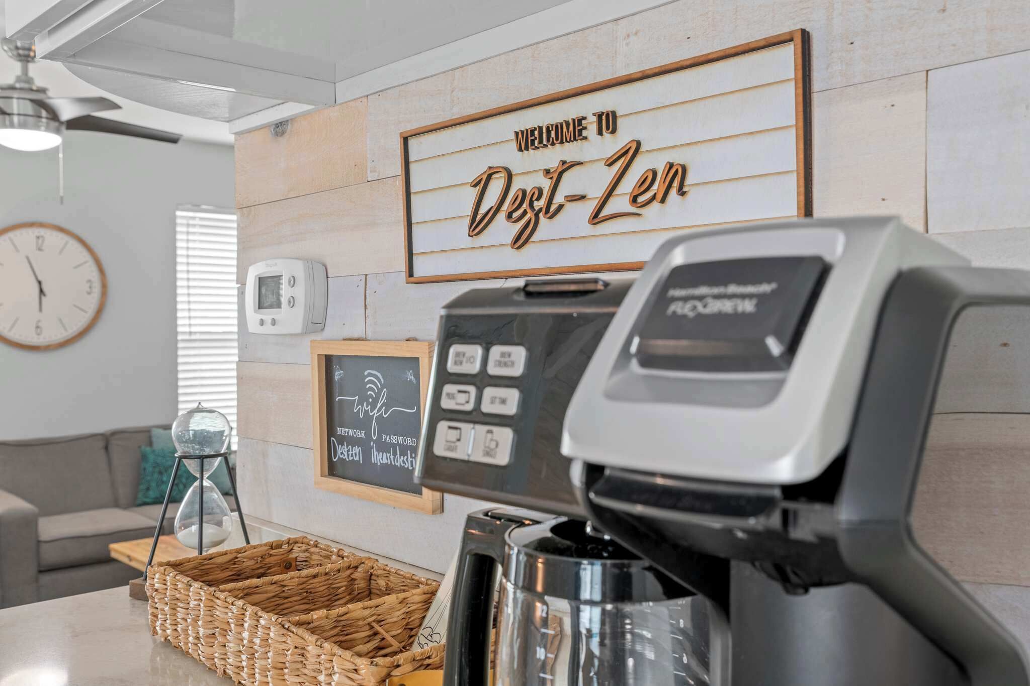 Una macchina del caffè, una sveglia, un termostato e un cartello di benvenuto in un ambiente moderno.