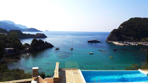 Vista litoral amb piscina, embarcacions i un terreny rocos.