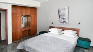 Una camera da letto con un letto, un'armadio in legno e un quadro appeso al muro.