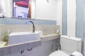 A bathroom with a white sink, a mirror, and a toilet. - PF10 - Casa 3 Suítes a 300m da Praia (Mata de São João)