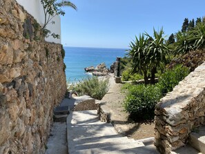 A stone staircase leading to a coastal area with a view of the sea. - Coronado 73 Apartment by Casasol (Nerja)
