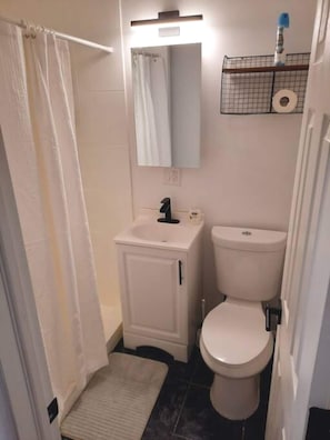 Un baño pequeño con inodoro, lavabo y espejo.