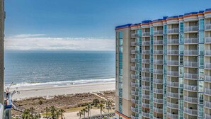 Un hôtel de grande hauteur doté de nombreux balcons donnant sur une plage.