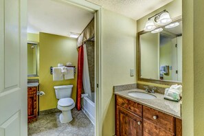 Une salle de bain avec des toilettes, un lavabo et un miroir.