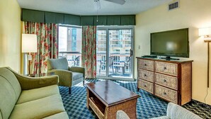 A hotel room with a sofa, armchair, and a television on a cabinet. - · 3Bdrm Gorgeous Condo - Private Balcony - Multiple Pools (Myrtle Beach)