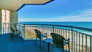 Un balcon avec vue sur la plage et l’océan.