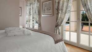 A bedroom with a bed, a window with curtains, and a framed picture on the wall. - Villa Palazzo di Cleo with Pool (Vabriga)