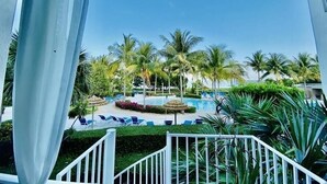 A pool area with palm trees and lounge chairs. - PARADISE FOUND! (Key Largo, FL 33037)