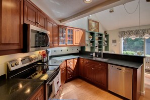 Enjoy meal preparation in this well-equipped kitchen with a large island, sink, and ample counter space.
