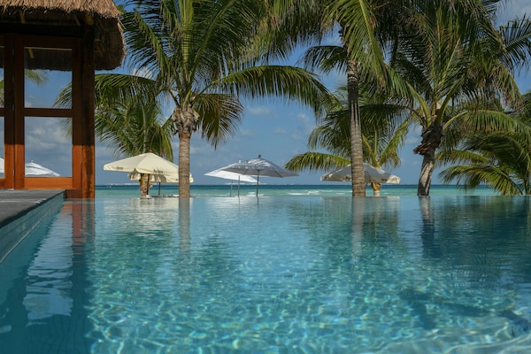 Una piscina al aire libre, sillones reclinables de piscina
