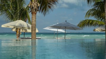 Una piscina al aire libre, sillones reclinables de piscina