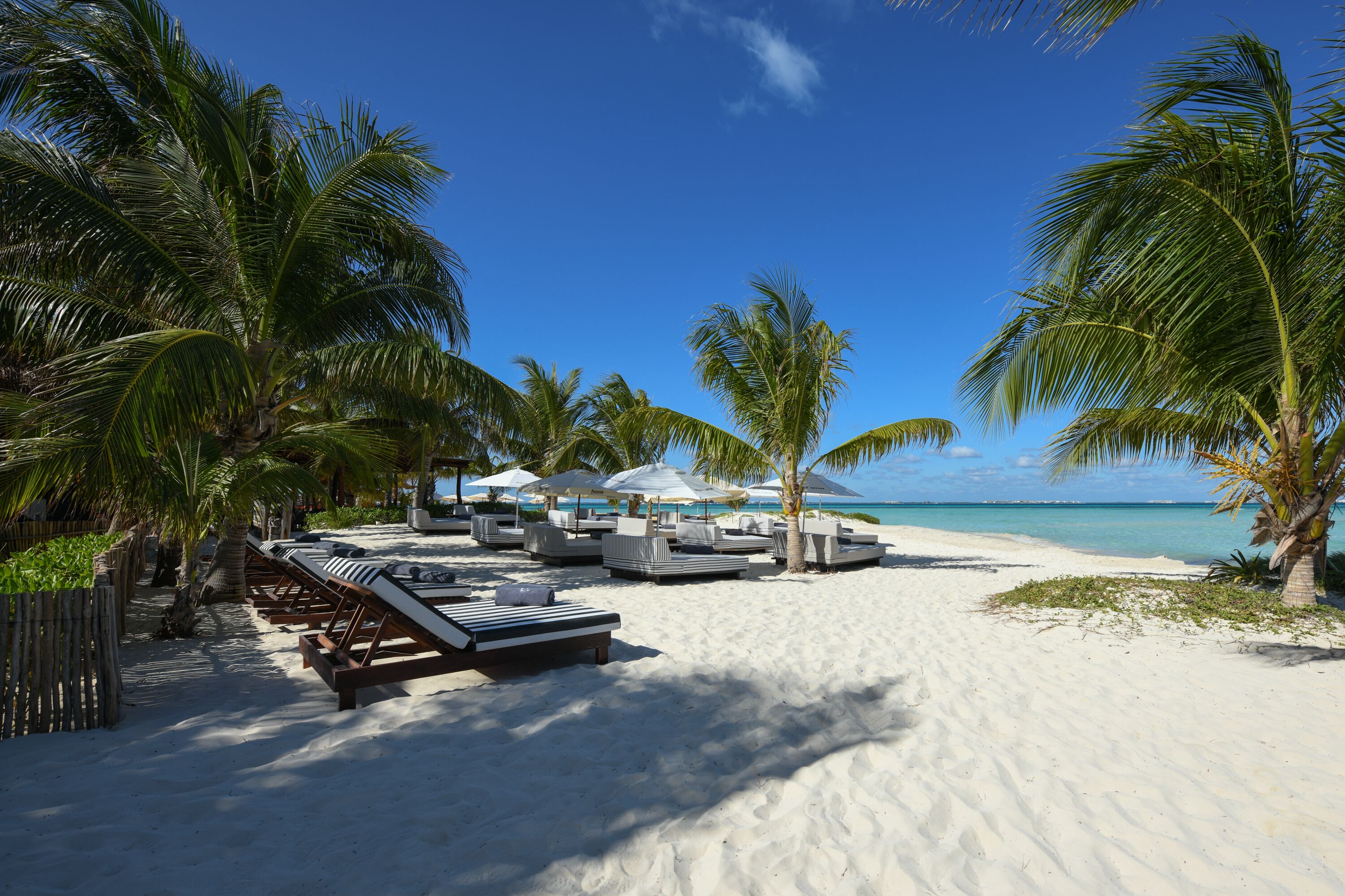 On the beach, white sand, sun-loungers, beach umbrellas
